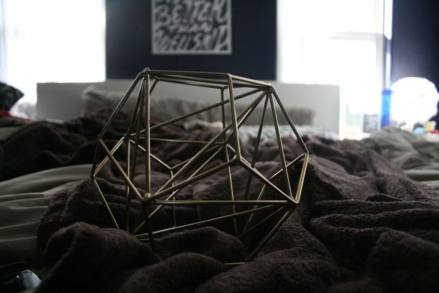 Geometric Metal Sculpture on Cozy Bed with Throws - Download Free Stock Images Pikwizard.com