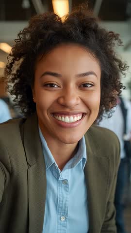 Smiling professional woman recording vertical video while moving closer in coworking space