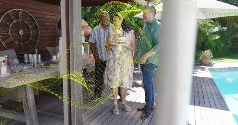 Woman holding cake chatting with friends on poolside deck with yellow digital overlay