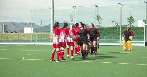 Female Field Hockey Teams in Friendly Handshake on Turf