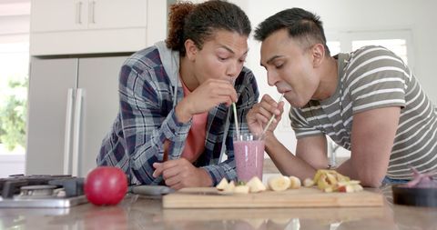 Happy Couple Sharing Smoothie at Home