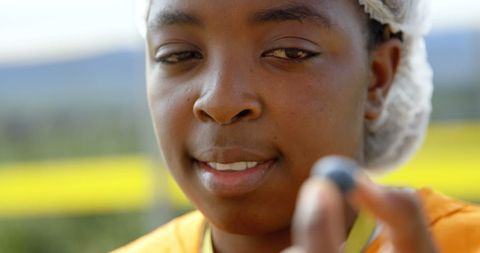 Close-up of Worker Inspecting Fresh Blueberry in Field