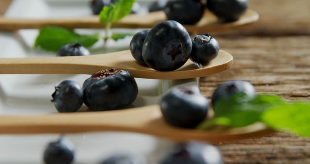 Close-up of Fresh Blueberries on Wooden Spoons with Mint Leaves - Download Free Stock Images Pikwizard.com