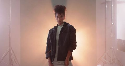 African American woman in leather jacket backlit studio portrait with warm halo lighting