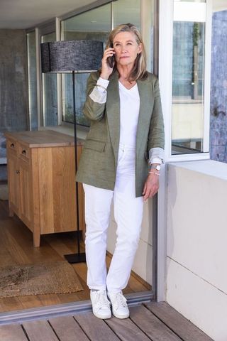 Elegant senior woman using smartphone in modern home interior