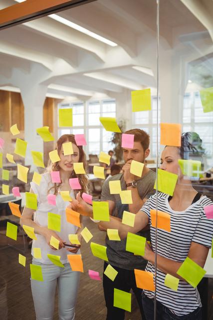 Business executives reading sticky notes in office