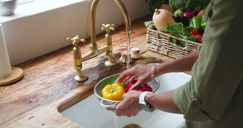 Rustic Kitchen Scene with Woman Washing Bell Peppers at Farmhouse Sink