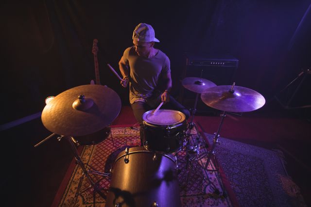 High angle view of male drummer performing in nightclub
