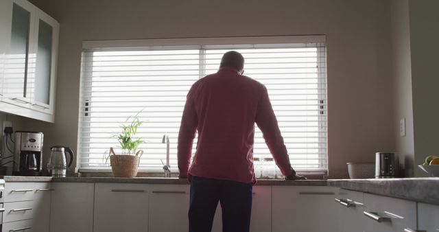 Image of back view of african american man walking in kitchen. Leisure, relax and spending time at home concept.