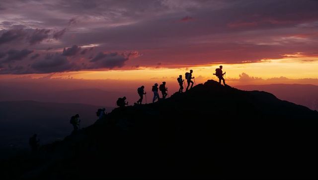 Trekking Adventurers Climbing Mountain Ridge at Sunset