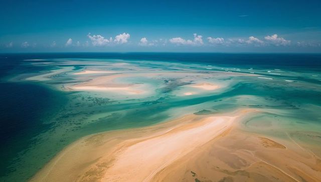 Aerial drone view of turquoise sandbars and shallow lagoons revealing reef patterns