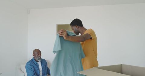 Father and Son Unpacking Boxes in New Home Living Room