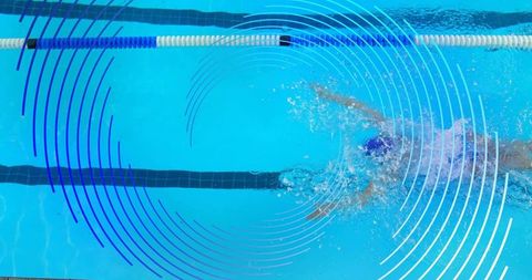 Overhead freestyle swimmer cutting through lane with blue circular graphic overlays