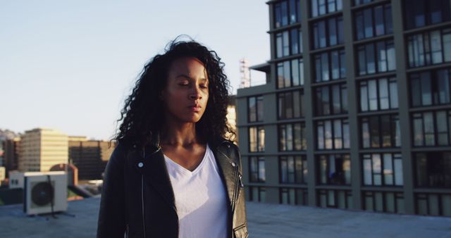 Young woman meditating on urban rooftop at sunrise - Download Free Stock Images Pikwizard.com