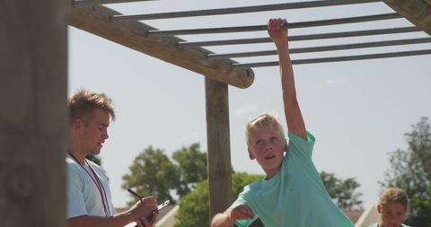 Boy Crossing Monkey Bars During Outdoor Bootcamp Challenge - Download Free Stock Images Pikwizard.com