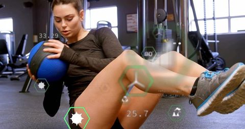 Twisting woman holding medicine ball with fitness hud overlay for core and balance training