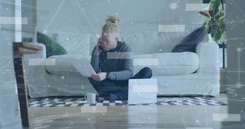 Man Multitasking at Home Office Reviewing Documents in Modern Living Room