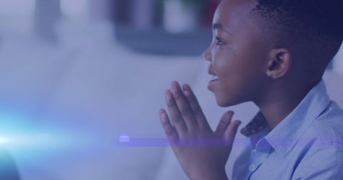 Joyful african american boy clapping hands at home