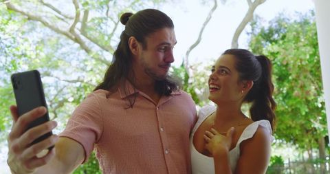 Smiling Couple Embracing Outdoors in Sunlit Trees