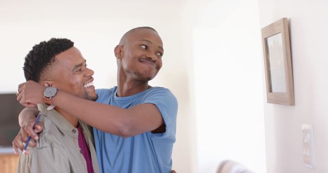 Happy diverse gay couple smiling and embracing at home - Download Free Stock Photos Pikwizard.com
