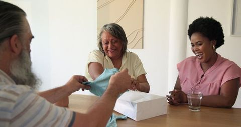 Senior Woman Receives Gift from Friends at Celebration Gathering