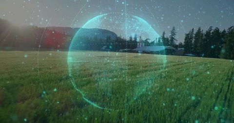Holographic turquoise globe hovering over farmland meadow with barn and sun flare