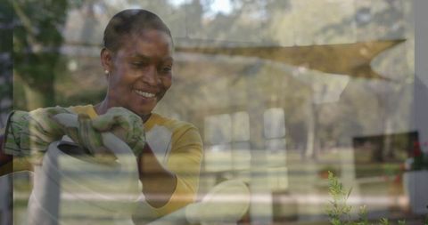 Woman Hydrating Potted Plants Through Glass Reflection
