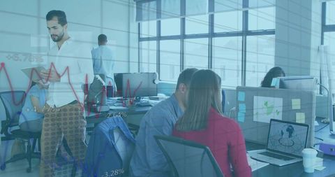 Team collaborating and analyzing data dashboards in modern open-plan office
