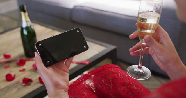 Caucasian woman with champagne making valentine's day image call on smartphone, copy space on screen. valentine's day celebration, romance and communication technology.