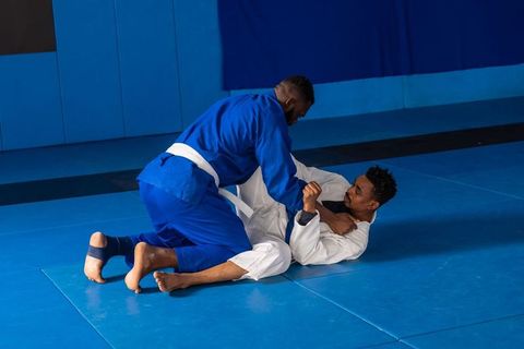 Two Men Grappling in Martial Arts Gym in Intense Match