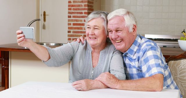 Senior couple taking selfie at home 