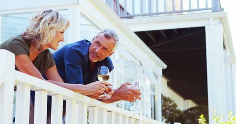 Mature Couple Enjoying Wine on Sunny Balcony