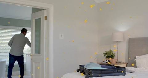 Man packing suitcase in bright minimalist bedroom with open door and daylight