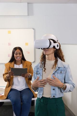 Diverse women testing vr headset during workplace training and team collaboration
