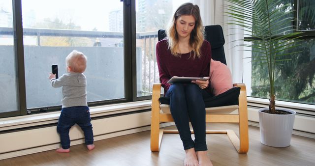 Woman Working on Tablet While Baby Standing by Window - Download Free Stock Images Pikwizard.com