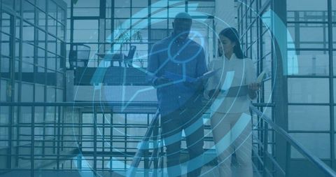 Business Colleagues Walking Down Staircase Reviewing Tablet with Futuristic HUD Overlay
