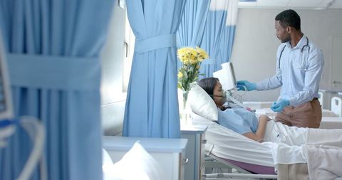 Doctor caring for patient in hospital room