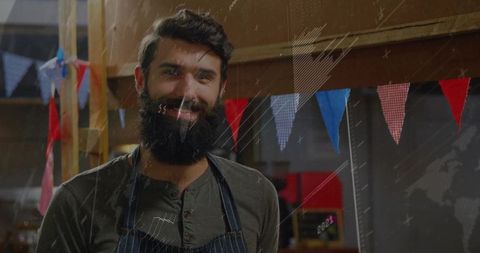 Bearded artisan in marketplace with bunting decoration