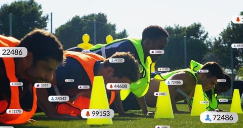 Performing team push-up drill on sunlit field wearing neon bibs with data overlays