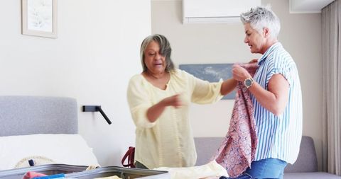 Senior Couple Packing Suitcase in Bedroom for Retirement Travel