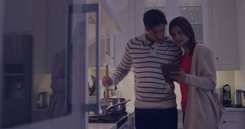 Couple Cooking Together in Kitchen While Using Tablet