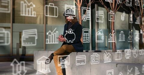 Young man using smartphone on urban planter bench surrounded by finance business icons