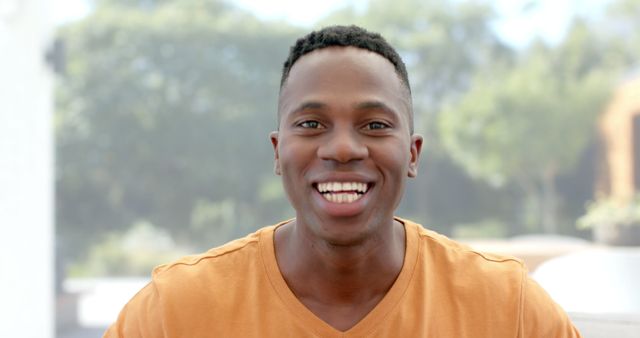 Smiling Young African American Man in Orange Shirt Outdoors - Download Free Stock Images Pikwizard.com