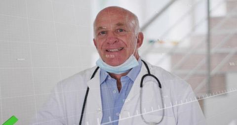 Senior doctor smiling with stethoscope and lowered mask in clinical corridor with HUD