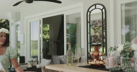 Women Enjoying Celebratory Gathering at Home with Desserts and Flowers