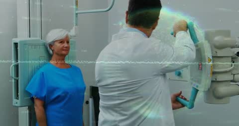 Technician Adjusting X-Ray Machine with Patient in Hospital