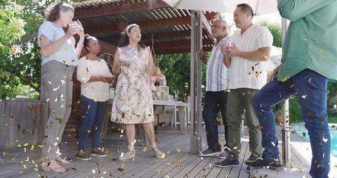Backyard Celebration Featuring Woman Wearing Floral Dress and Sash on Wooden Deck