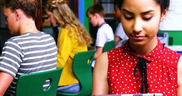 Schoolgirl using digital tablet while other students studying on computer in classroom at school - Download Free Stock Photos Pikwizard.com