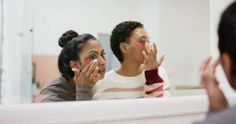 Women Applying Hydrogel Eye Patches in Bathroom for Skincare