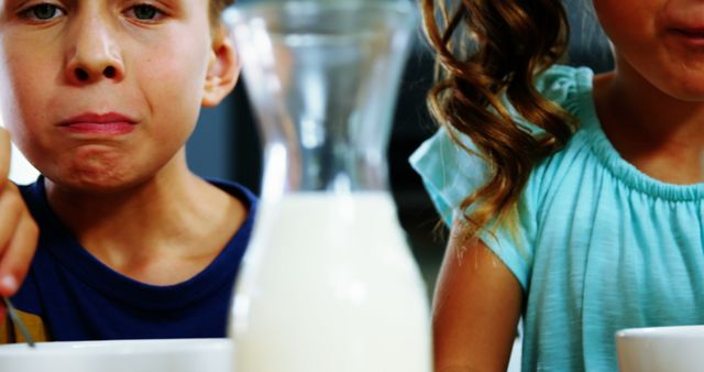 Kids Eating Breakfast with Focus on Bottle of Milk - Download Free Stock Photos Pikwizard.com